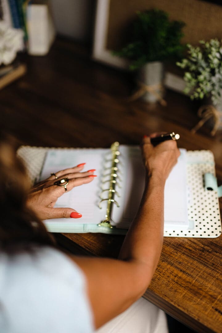 A person writing in an open notebook.